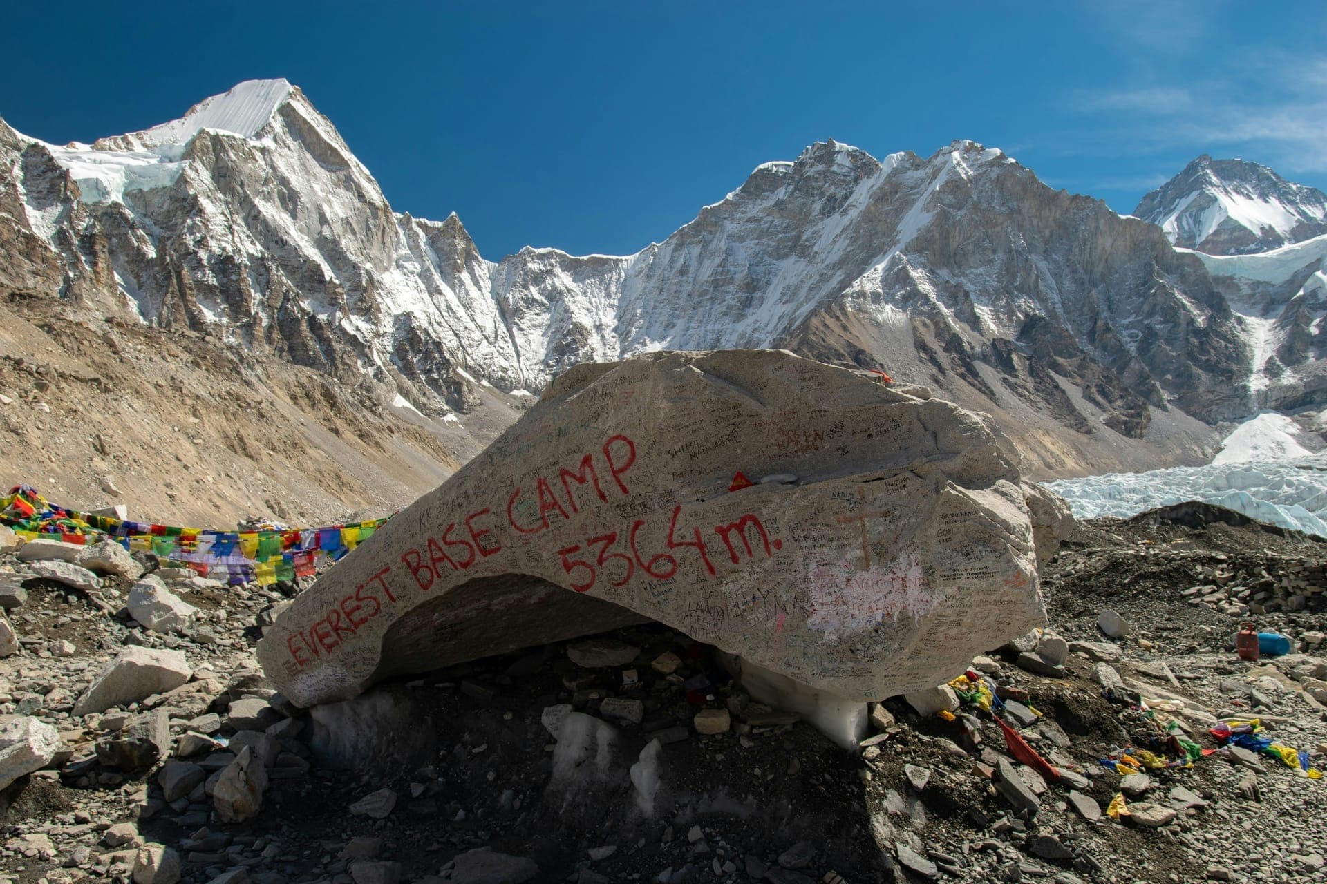 The Everest Base Camp marker rock at 5,364 m, strung with prayer flags