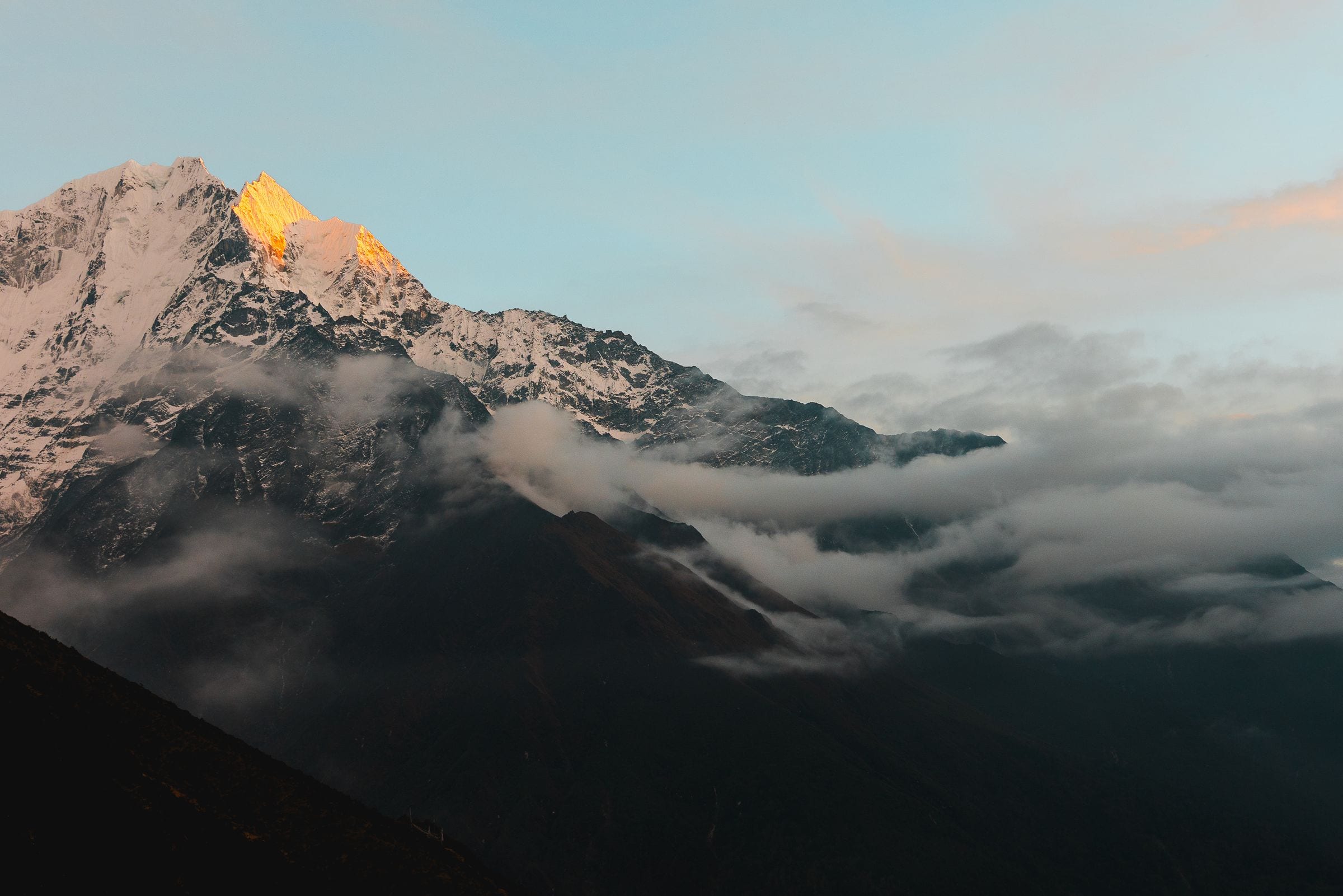 Sunrise light on Himalayan summits above a valley of cloud