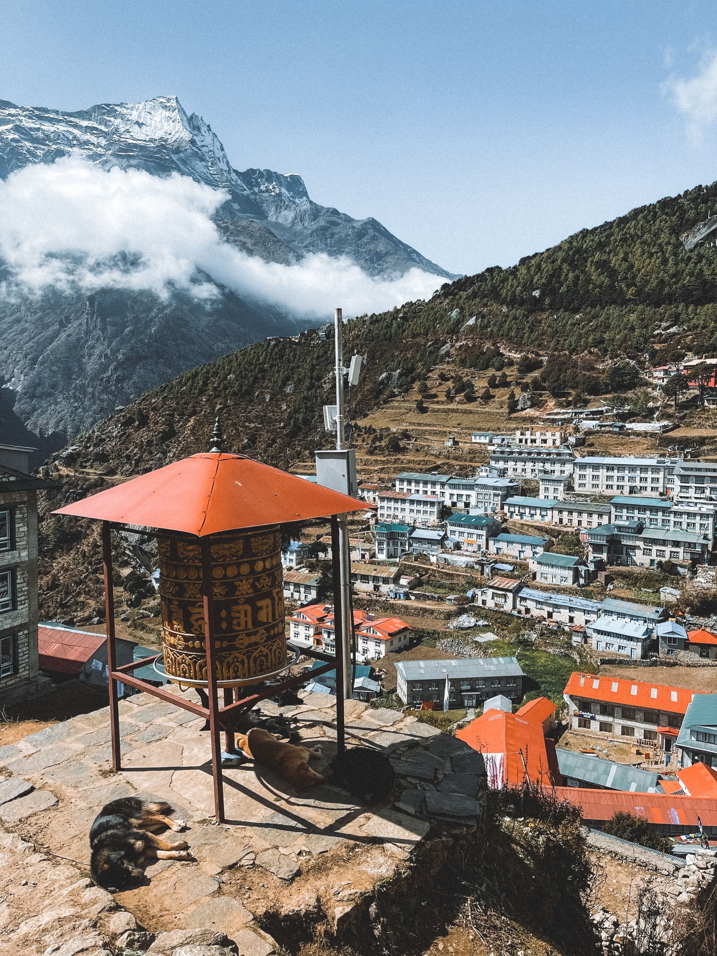 The painted lodges of Namche Bazaar stacked below a snow peak