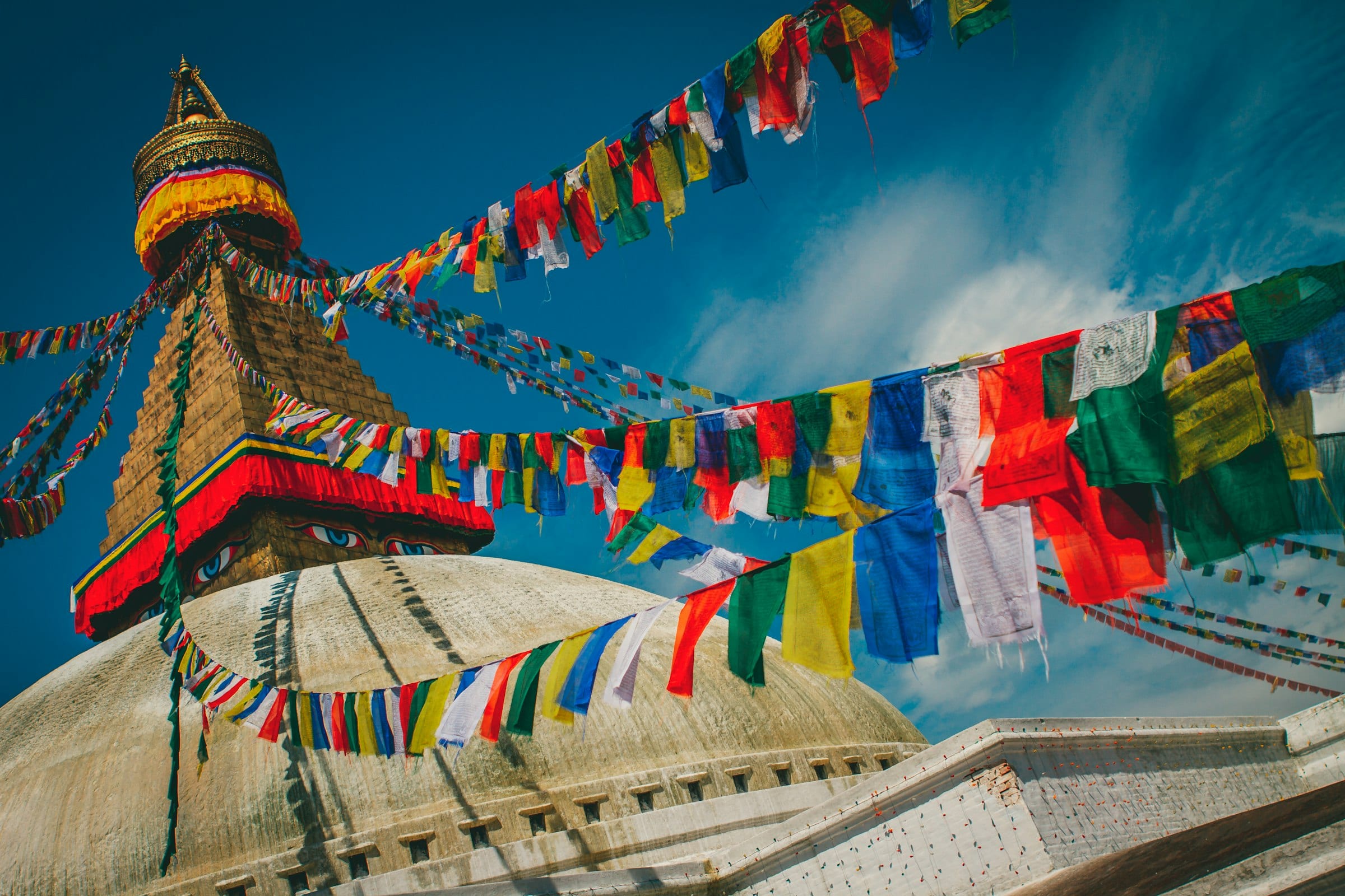 Prayer flags strung from the gilded spire of Boudhanath stupa