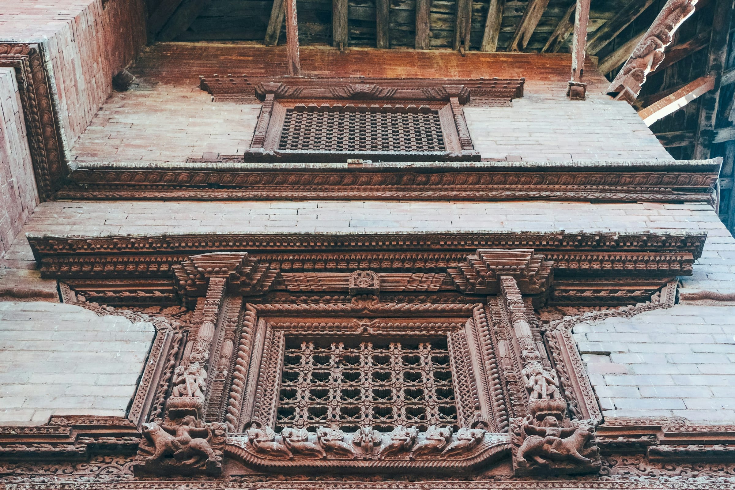 A carved timber window in a brick Newar facade