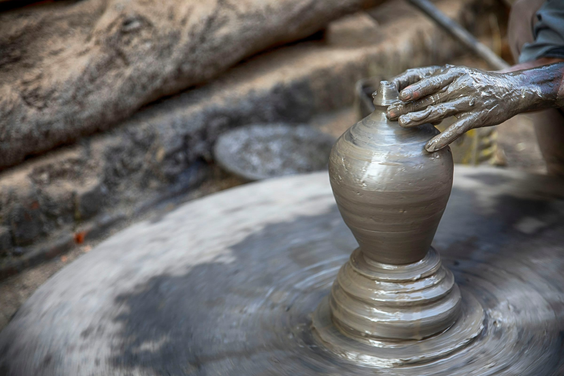 A potter turning a clay vessel on a wheel in Bhaktapur