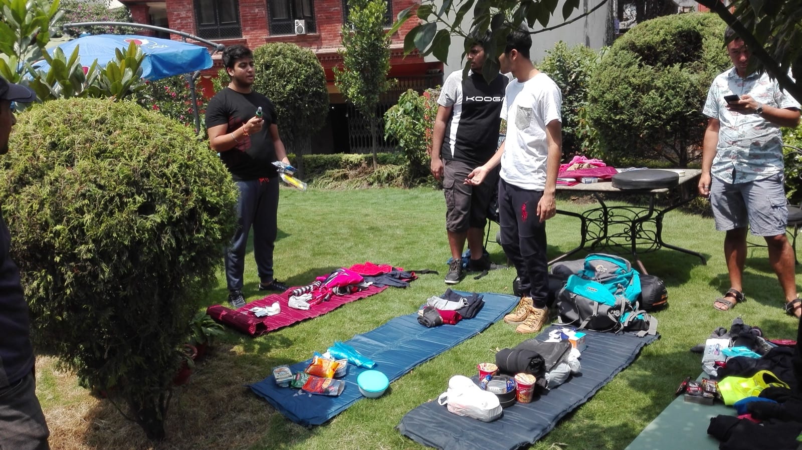 Students laying out their expedition kit on sleeping mats on a hotel lawn in Kathmandu during a kit check