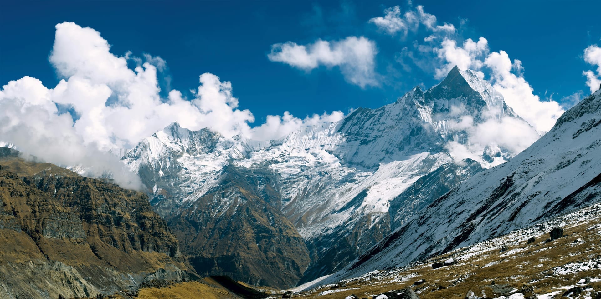 Machhapuchhre (Fishtail) and snow-covered Annapurna ridges above a high rocky valley