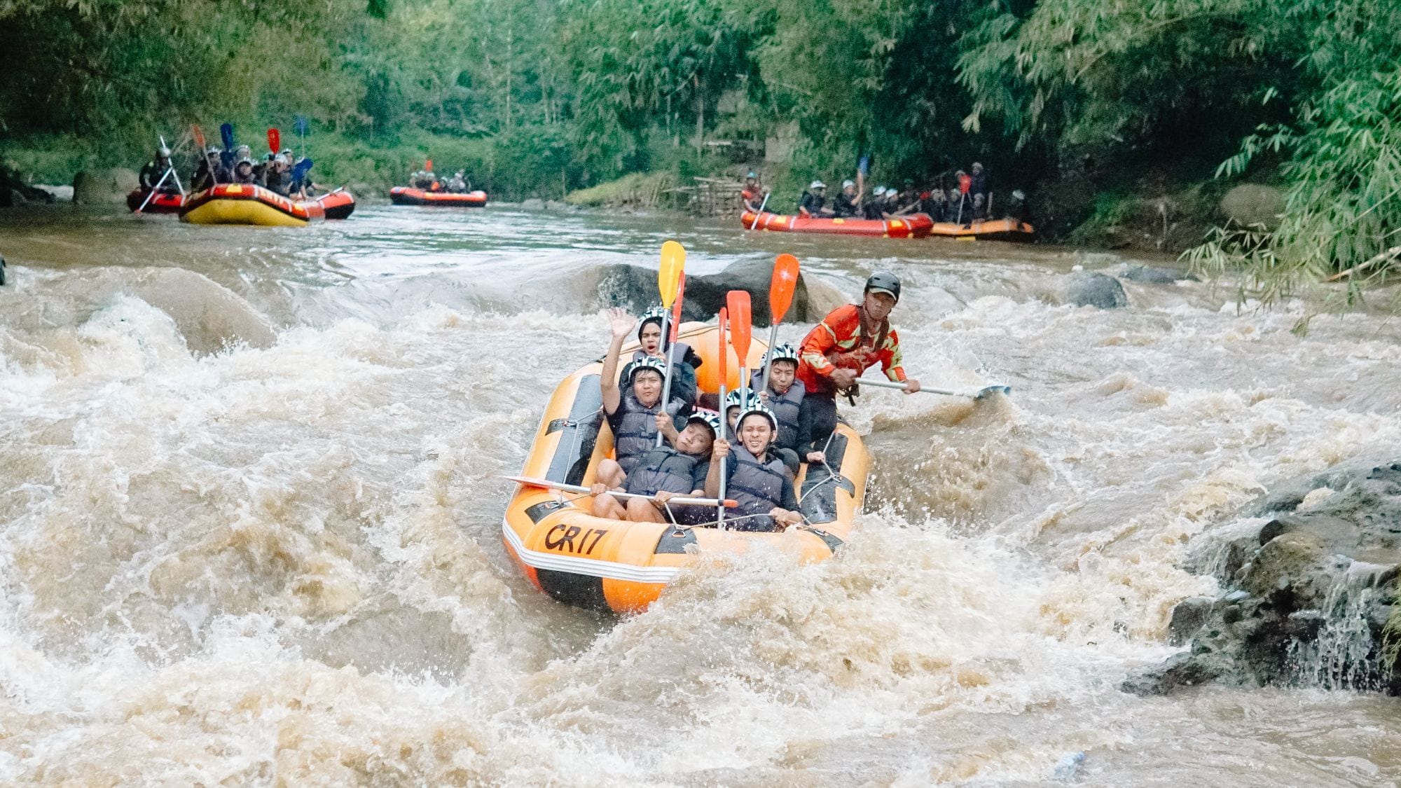 A raft crew running white water through a green gorge