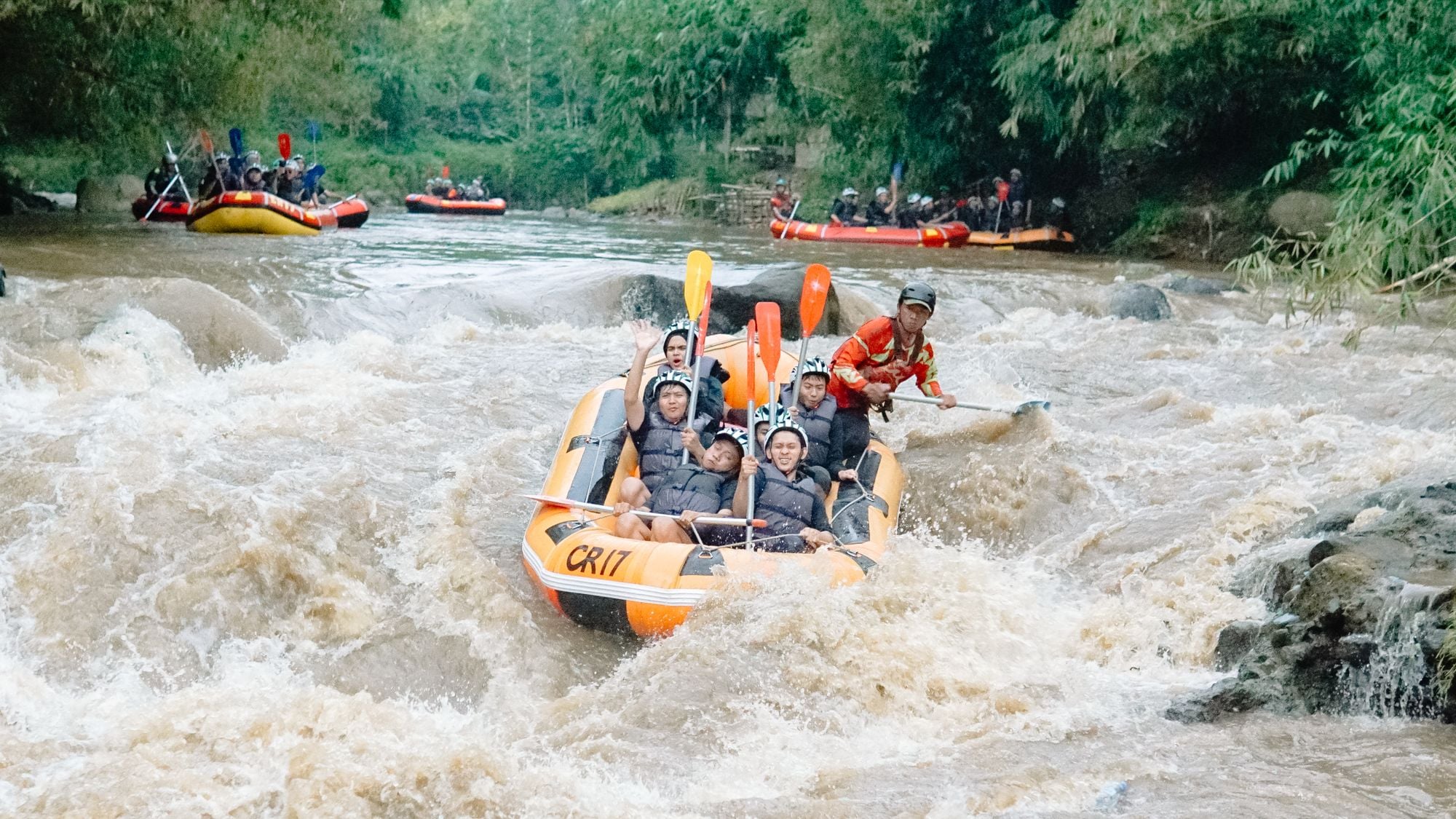 A raft crew running white water through a green Nepali gorge