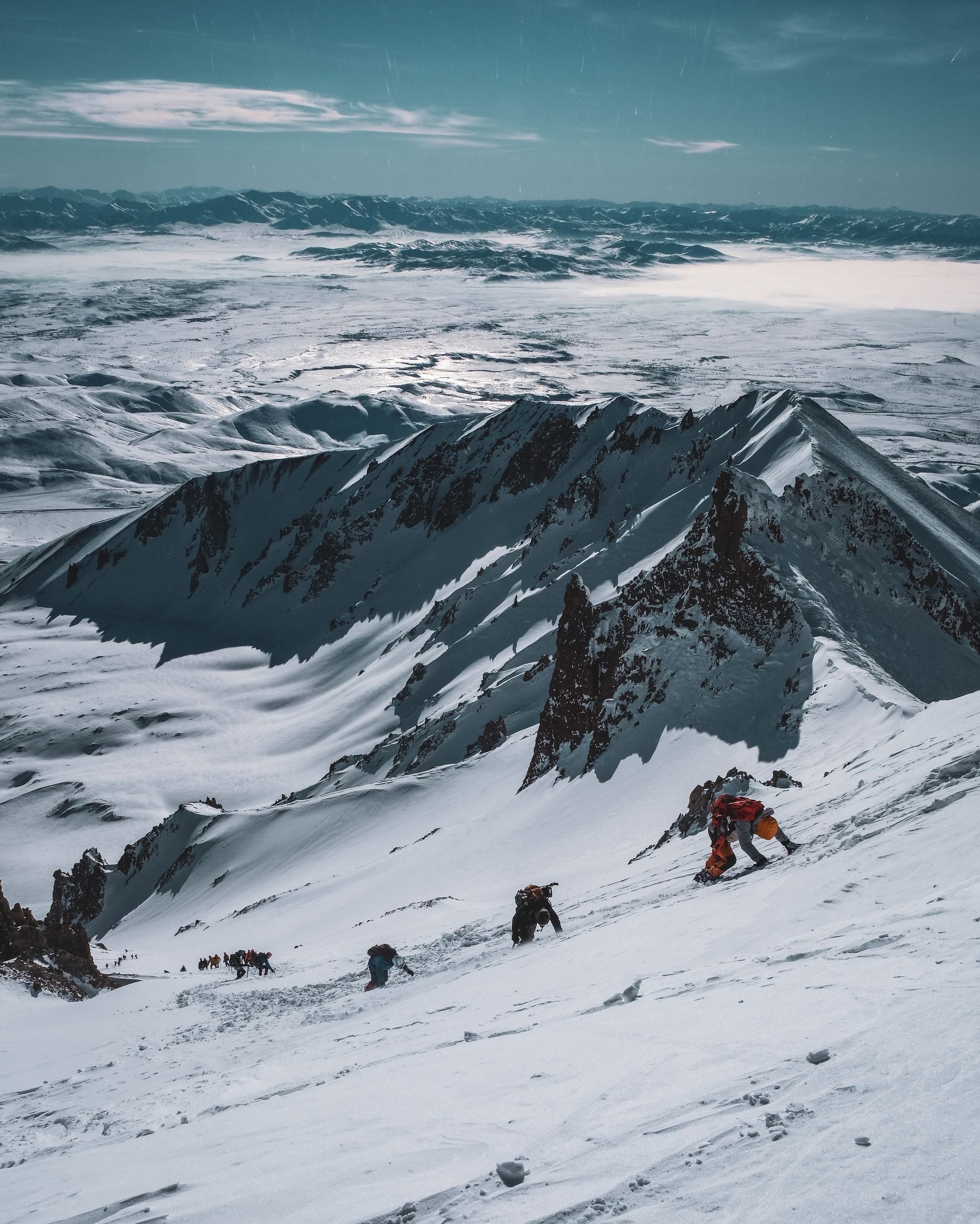 A rope team ascending a snow slope on a Himalayan climb