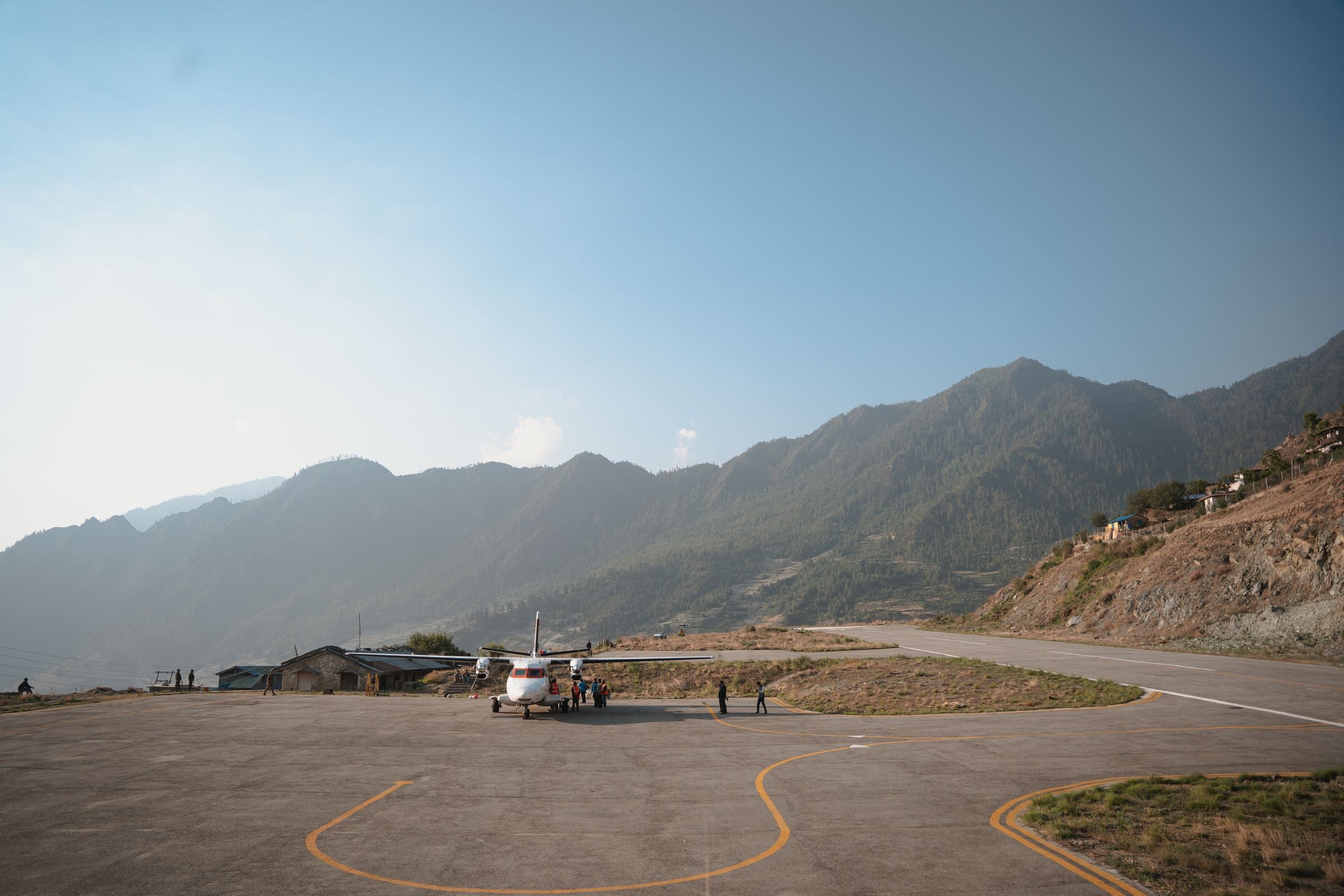 The airstrip at Lukla on its shelf above the valley, ridges behind it