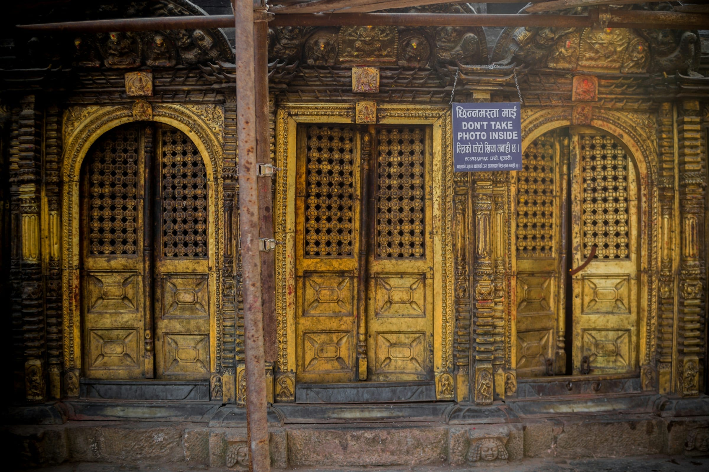 Ornate gilded doors and carved timber at the Changu Narayan temple
