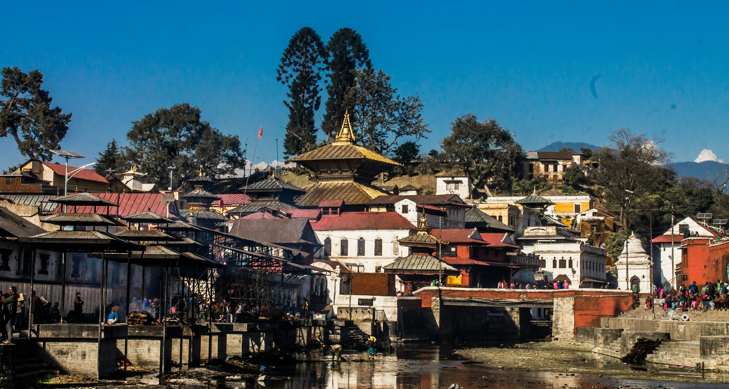 Pagoda roofs and cremation ghats along the Bagmati river at Pashupatinath