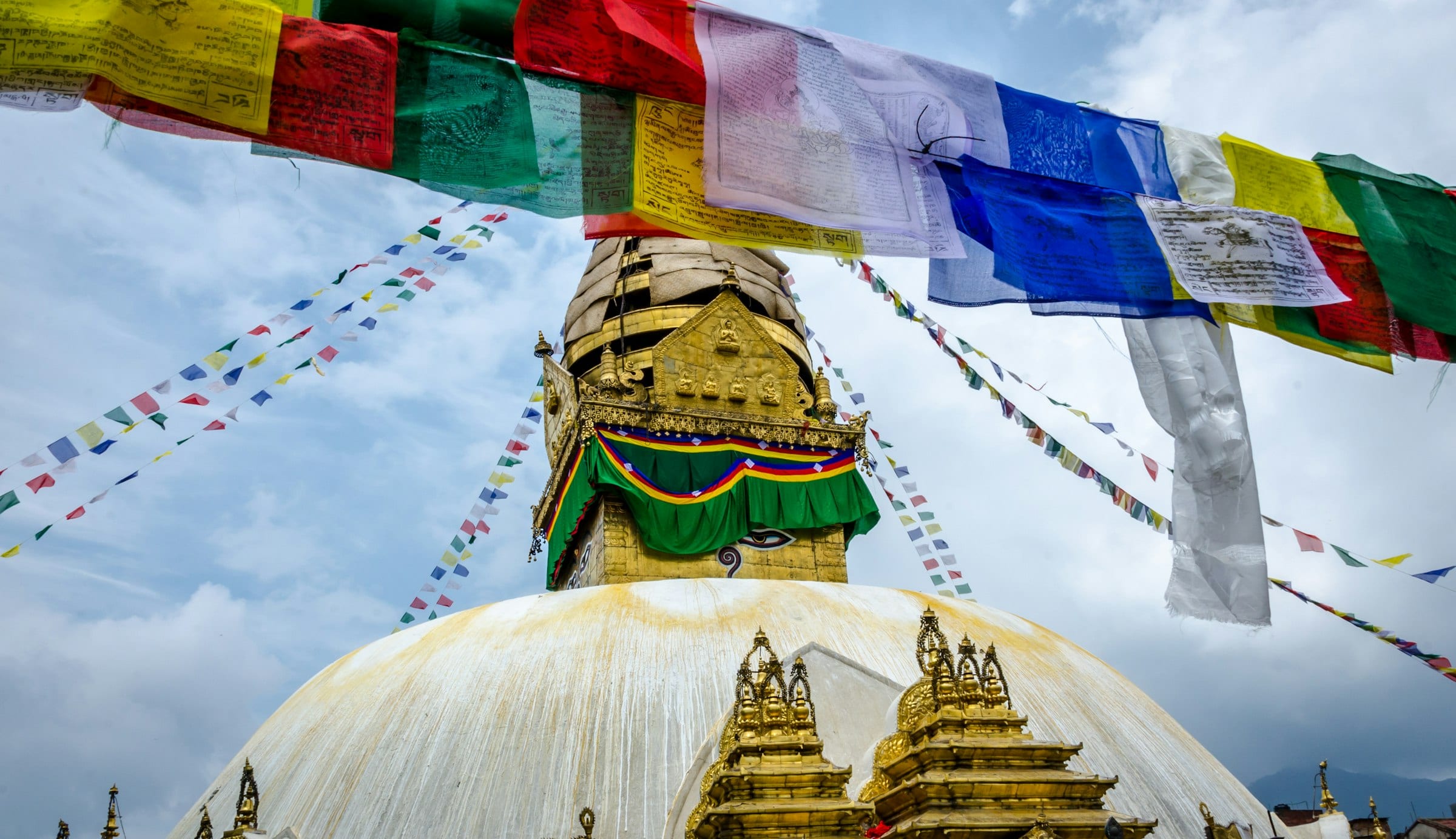 The gilded spire of Swayambhunath stupa in Kathmandu hung with prayer flags