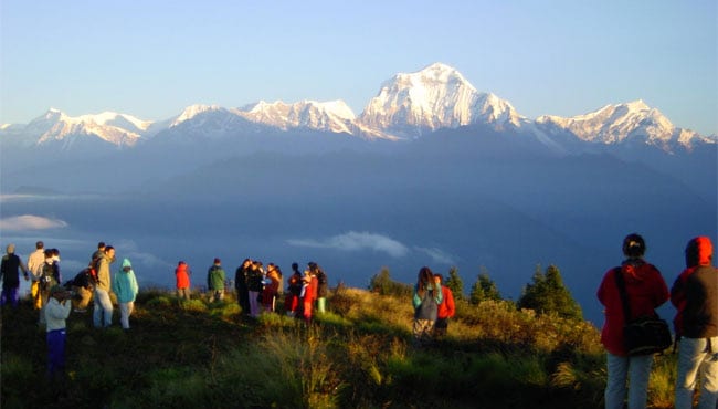 Trekkers watching sunrise light the snow peaks of the Dhaulagiri range from the top of Poon Hill