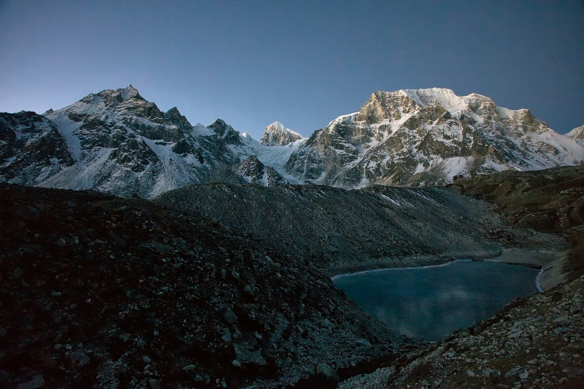 A glacial lake below the snow peaks of the Manaslu circuit